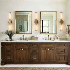 a bathroom with double sinks and two mirrors on the wall next to eachother