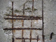 rusty iron bars on the side of a concrete wall