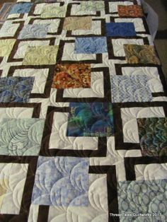 a quilted table topper with many different colors and designs on it, sitting on a table