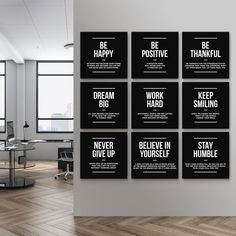 black and white motivational posters on the wall in an office setting with wooden floors