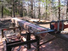 a large metal pipe sitting in the middle of a forest