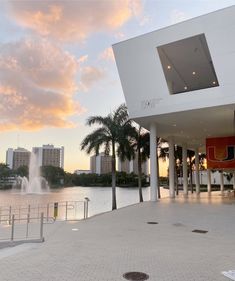 a large white building next to a body of water with a fountain in front of it