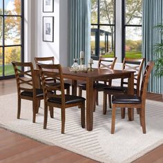 a dining room table and chairs with windows in the background