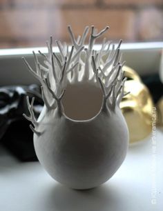 a white vase sitting on top of a table next to other items in a box