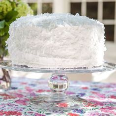 a white cake sitting on top of a glass plate