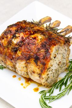 a close up of a piece of meat on a plate with herbs and seasoning