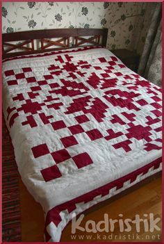 a bed with a red and white quilt on it