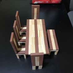 a wooden table and chairs made out of wood planks on a black countertop