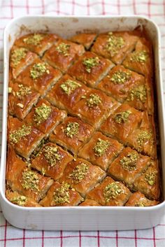 a casserole dish filled with bread and topped with pistachio