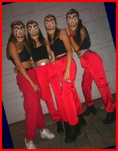 four women with painted faces and red pants are posing for a photo in front of a garage door