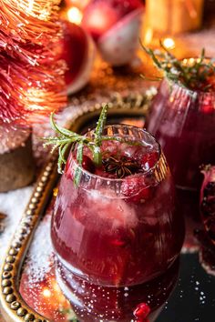 pomegranates are garnished with greenery in glasses on a tray