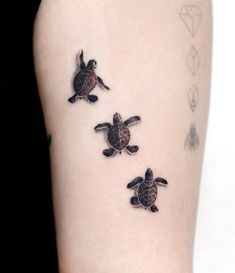 three small turtles on the back of a woman's arm