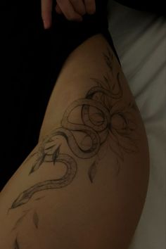 a woman's thigh with a snake tattoo on it