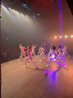 a group of dancers performing on stage in front of an audience