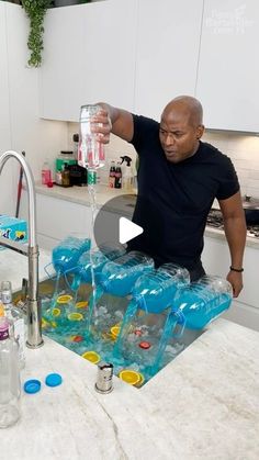 a man pours water from a faucet into plastic containers in the kitchen