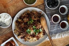 a table topped with plates of food and bowls of sauces on top of it