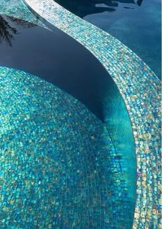 an empty swimming pool with blue and green tiles