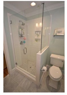 a white toilet sitting next to a shower in a bathroom on top of a tiled floor