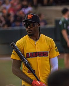 a baseball player holding a bat in his hand and wearing sunglasses on the other side