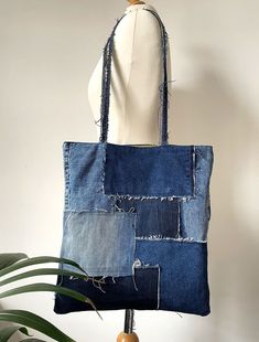 a bag made out of old jeans hanging on a mannequin