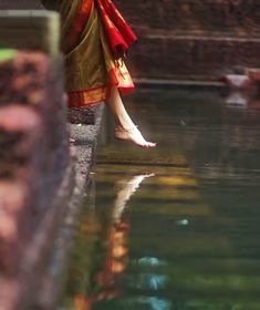 a woman standing on the edge of a body of water