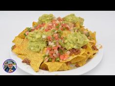 a white plate topped with nachos covered in guacamole and salsa