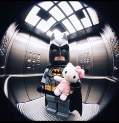 a lego batman with a hello kitty doll in it's hand and the image is taken through a circular lens