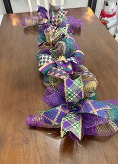 a purple and green bow sitting on top of a wooden table