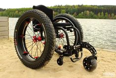 a wheel chair sitting on top of a sandy beach next to a body of water