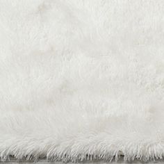 a white rug is laying on top of a wooden floor and it looks like fluffy fur