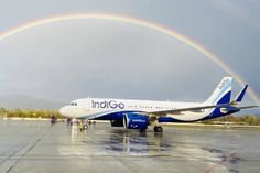 an airplane on the tarmac with a rainbow in the background