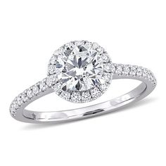 a white gold engagement ring with diamonds on the band and an oval center stone surrounded by round