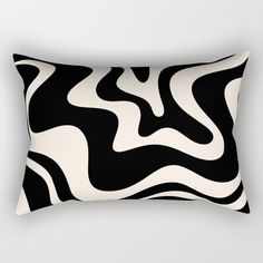 a black and white rectangular pillow with wavy lines on the front, in an abstract manner