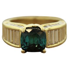 This ring features a fine blue tourmaline, known as indicolite in the trade, weighing 3.16 carats. It is cut as a cushion and has a deep vivid color and free of any noticeable inclusions. It is complemented by 2.47 carats of tapered baguette cut diamonds which run along the sides of the 18k yellow gold ring. Ring Size 5.5 Indicolite Ring, Diamond Gold Ring, Indicolite Tourmaline, Blue Tourmaline, Baguette Cut Diamond, 18k Yellow Gold Ring, Diamond Gold, Baguette Cut, Vivid Color