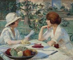 two women sitting at a table in front of a plate of fruit on the table