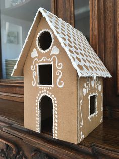 a cardboard house sitting on top of a wooden table