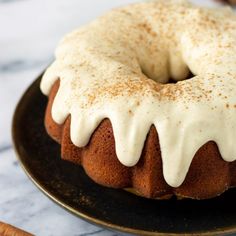 a bundt cake with white icing and cinnamon sticks