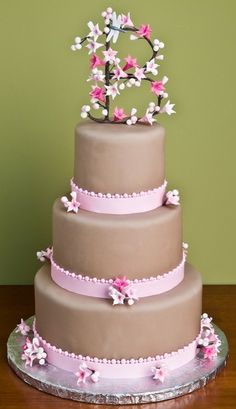 a three tiered cake with pink and white flowers