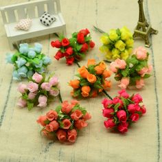 small colorful flowers sitting on top of a table next to a miniature bench and chair