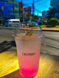 a pink drink sitting on top of a wooden table