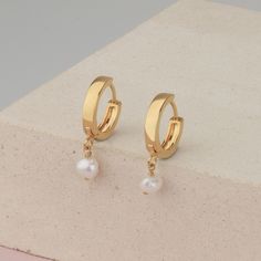 Small hoop earrings with a tiny pearl charm, freshwater pearl on a small hoops earring made of 14k gold filled. These dainty earrings are perfect to wear in the ear lobe, as a first piercing. Minimalist earrings are just perfect and really easy to wear and combine with more earrings. With the latch, backs make them really comfy to wear every day and on every occasion. Hoops size 16mm Pearl charm size 6mm This listing is for a PAIR of hoops earrings. Take a look at the matching necklace: https:// Delicate Huggie Hoop Earrings With Pearl Charm, Single Pearl Huggie Hoop Earring, Dainty Huggie Earrings With Pearl Charm As Gift, Dainty Pearl Charm Huggie Earrings As Gift, Dainty Pearl Charm Huggie Earrings For Gifts, Gift Pearl Drop Huggie Hoop Earrings, Delicate Small Hoop Pearl Earrings With Pearl Charm, Gift Huggie Hoop Earrings With Pearl Drop, Dainty Pearl Huggie Hoop Earrings