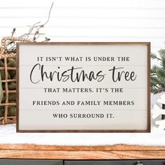 a wooden sign that says it isn't what is under the christmas tree that matters