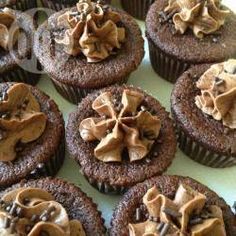 chocolate cupcakes with frosting and sprinkles arranged on a table