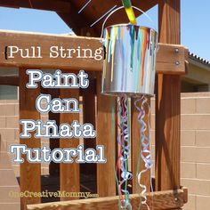 a metal can with streamers hanging from it's side and the words pull string paint can pinata tutorial