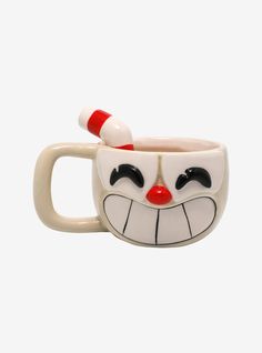 a ceramic mug with a clown face painted on it