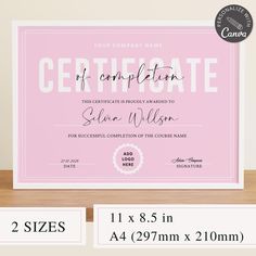 a pink certificate is displayed on a table with two sizes and measurements for each piece