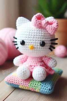 a hello kitty doll sitting on top of a pillow