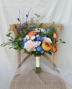 a bouquet of flowers sitting on top of a wooden chair