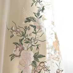 the curtain is decorated with flowers and leaves