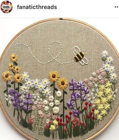 a cross stitch pattern with flowers and a bee